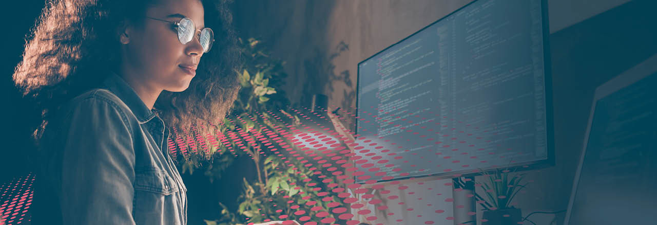 Una mujer codificando en un computador rodeado de un colorido gráfico de puntos/textura 